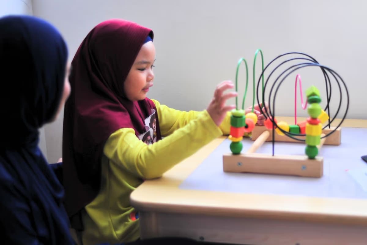 EIPP - Key Learning Area - Building Early Reading and Number Skills - Adeeva playing with a Montessori toy