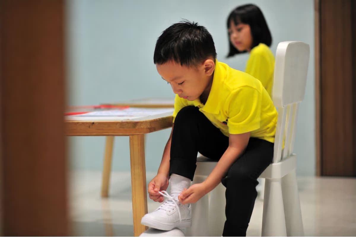 EIPP - Key Learning Area - Daily Living Skills - Boy tying his shoe laces